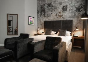 a bedroom with a bed and two chairs in it at Malmaison Hotel Leeds in Leeds