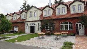 a house with chairs and tables in front of it at Pension Kchischowka in Vetschau