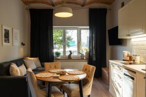 a kitchen and living room with a table and a couch at Villa la Olive Premium Apartaments-Luxury Standard in Oświęcim