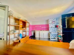 a kitchen with pink and blue walls and a wooden table at Pensão CasaDanilo in Portela