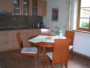 una cocina con mesa y sillas de madera, mesa y sillón en Apartment 53 Zvíkovské Podhradí en Zvíkovské Podhradí