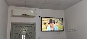 Un televisor de pantalla plana en una pared junto a una puerta. en Excelente Ubicación con Cochera Privada, en Ciudad Evita