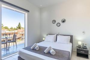 a bedroom with a bed and a balcony at Angela Hotel & Apartments in Gouvia