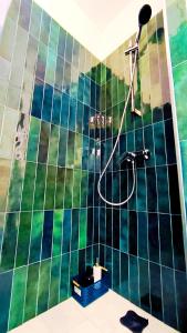 a bathroom with a shower with green and black tiles at Levalet BNB - La Défense Courbevoie in Courbevoie