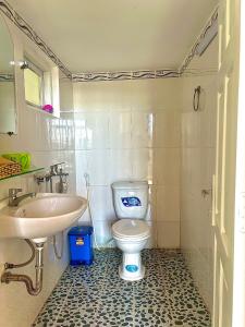 ein Badezimmer mit weißer Toilette und Waschbecken in der Unterkunft Pate's Home in Da Lat + 15 Fotos