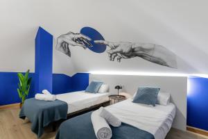 a room with two beds and a mirror on the wall at Las Canteras Coastal Rooms - Only adults in Las Palmas de Gran Canaria