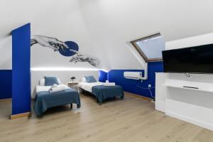 a room with two beds and a flat screen tv at Las Canteras Coastal Rooms - Only adults in Las Palmas de Gran Canaria