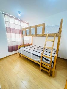 a bunk bed and a ladder in a room at El Oasis de Huacachina - Alojamiento in Ica