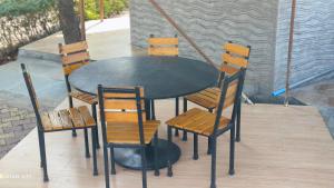 a black table with four chairs and a fire place at Thakur Farm in Palasdhari