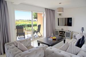 塔哈佐特Appartement luxe vue Mer & Golf -Taghazout Bay的客厅里有一张白色的沙发和一张桌子