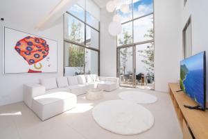 a living room with white furniture and a flat screen tv at Sofia Villa Phuket in Phuket Town