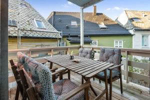 Una mesa y sillas de madera en un balcón. en Dinbnb Homes I Family Friendly Home in Historical Sandviken, en Bergen