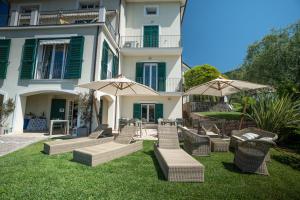 a group of chairs and umbrellas in front of a building at Albergo Blueline in Tellaro