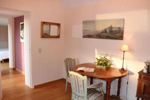 uma sala de jantar com uma mesa de madeira e cadeiras em Chambre d'hôtes CitaBel'Air em Namur