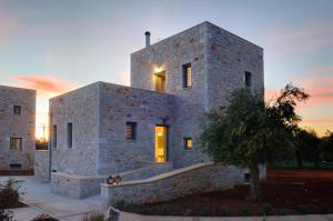 ein Steingebäude mit einem Baum davor in der Unterkunft Nikoloudi Estate in Agios Nikolaos