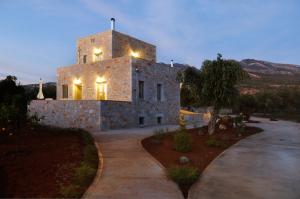 a large stone building with lights on top of it at Nikoloudi Estate in Agios Nikolaos