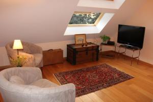 sala de estar con TV de pantalla plana y muebles en Chambre d'hôtes CitaBel'Air, en Namur