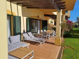 a patio with white chairs and a table on a house at La Manga Club Hacienda Del Golf in Atamaría