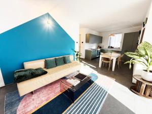a living room with a couch and a blue wall at Appartamento Angeli in Levico Terme