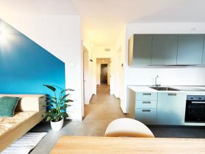 a kitchen with blue cabinets and a blue wall at Appartamento Angeli in Levico Terme