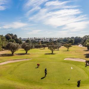 a group of people playing golf on a golf course at Orihuela Costa Sleeps 6 with Roof Terrace & Pool in Villacosta