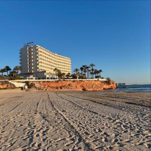 a view of a beach with a hotel in the background at Orihuela Costa Sleeps 6 with Roof Terrace & Pool in Villacosta