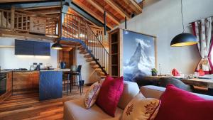 a living room with a couch and a staircase at Les Chalets de Rose in Breuil-Cervinia