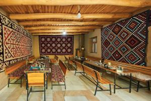 a restaurant with tables and chairs and colorful walls at Ulugbeks guesthouse in Yukary-Ukhum