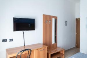 a room with a desk with a tv on a wall at Albergo Blueline in Tellaro