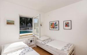 a white room with two beds and a window at Beautiful Villa Zman near sea in Dugi Otok in Žman +22 photos
