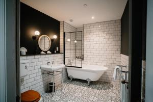 a bathroom with a tub and a sink at 89 The Merchants- Chic Aparthotel by The House of Danu in Edinburgh
