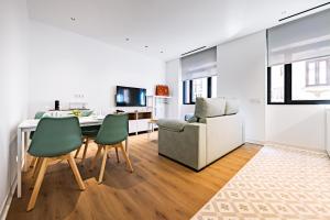 a kitchen and living room with a table and chairs at Apartamentos París Boutique Valladolid in Valladolid