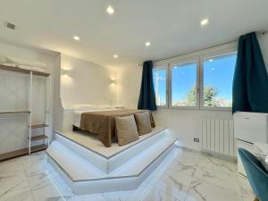 a white bedroom with a bed and some windows at Dimora Prometeo in Bari