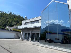 a glass building with a reflection of a mountain at Q Lodge 103 in Matten +6 photos