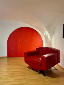 czerwone krzesło w pokoju z czerwoną szafką w obiekcie Aitnè - Holiday Apartments w Katanii