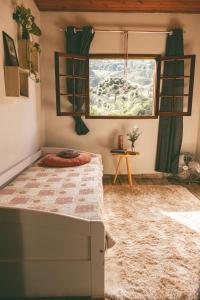 un dormitorio con una cama y una ventana en Casinha Pedra do Baú, en São Bento do Sapucaí 20 fotos más