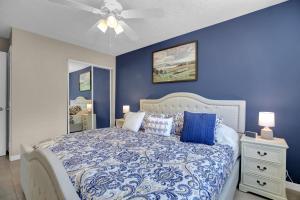 una camera blu con letto e ventilatore a soffitto di Key Largo Home with Spa and Pool a Key Largo Altre 25 foto