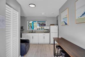una cucina con armadi bianchi, tavolo e frigorifero di Key Largo Home with Spa and Pool a Key Largo