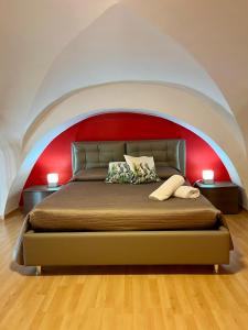 sypialnia z dużym łóżkiem i czerwoną ścianą w obiekcie Aitnè - Holiday Apartments w Katanii