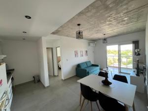 a living room with a table and a blue couch at Depto Yrigoyen, opcional COCHERA a 20 metros in Rafaela