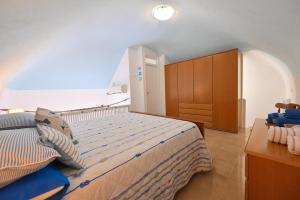 a bedroom with a large bed and a wooden cabinet at Beach House Ischia - Seafront & Aragonese Castle View - in Ischia Town