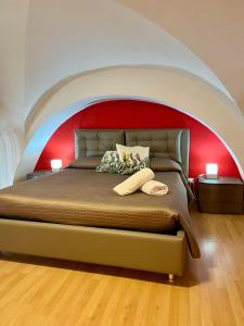 sypialnia z dużym łóżkiem z czerwonym zagłówkiem w obiekcie Aitnè - Holiday Apartments w Katanii