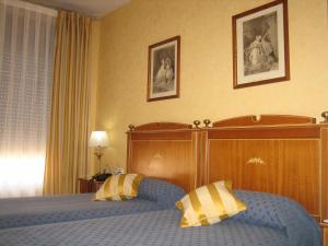 Łóżko lub łóżka w pokoju w obiekcie Hotel Santiago