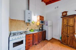 eine Küche mit einem weißen Herd und einem Kühlschrank in der Unterkunft La Querencia in Villa Carlos Paz + 30 Fotos