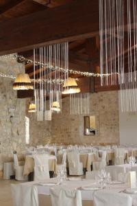 a dining room with white tables and chairs and chandeliers at Masseria Chinunno in Altamura