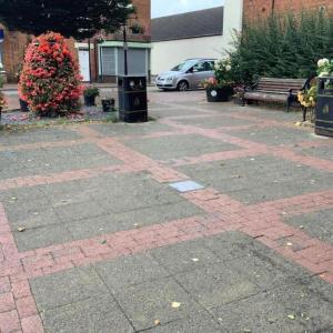 a brick parking lot with a bench and flowers at 1 Bed Flat - Sleeps 2 - Pets - Parking - Wifi in Kettering