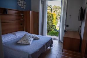 a bedroom with a bed and a sliding glass door at Albergo Blueline in Tellaro