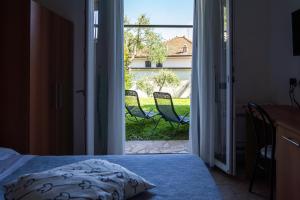 a bedroom with a door open to a patio with chairs at Albergo Blueline in Tellaro