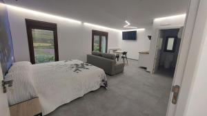 a bedroom with a bed and a couch and a table at LOVE Rural in La Mata de Morrella
