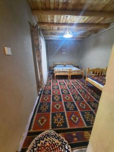 a room with two beds and a rug at Ulugbeks guesthouse in Yukary-Ukhum +30 photos